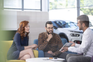 couple talking to car salesman