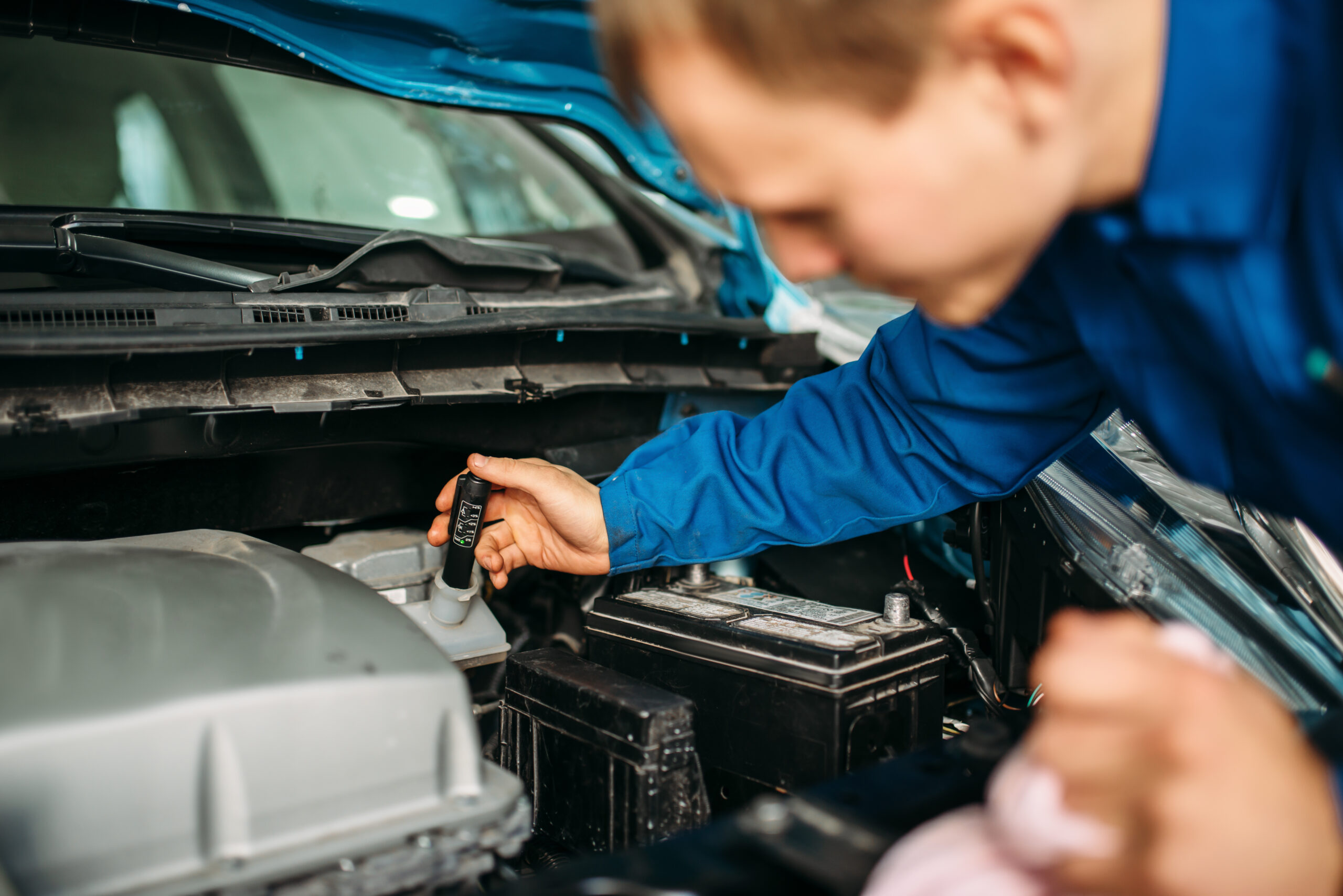 Technician checks brake fluid level in car