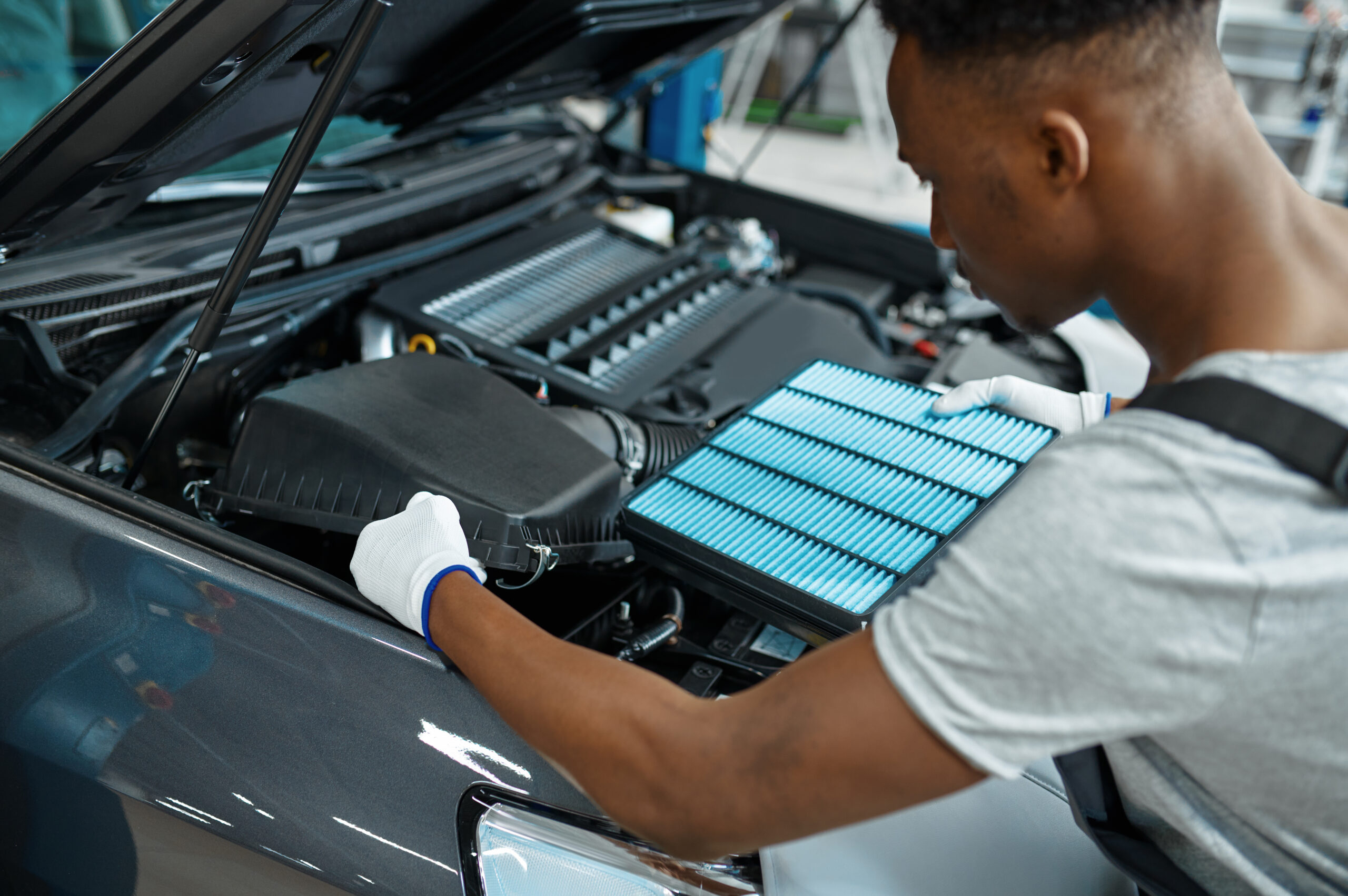 mechanic putting air filter in car