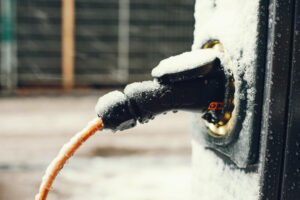 Charging an electric car with the power cable supply with snow on  them