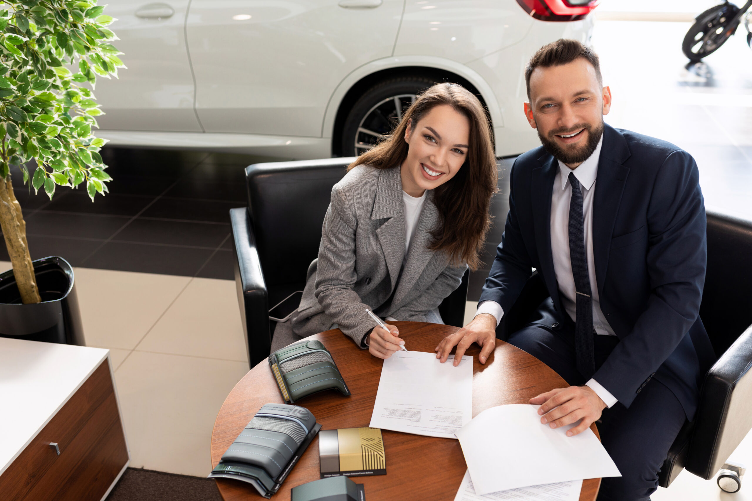 a young woman arranges a loan for a car purchase in a car dealership